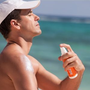 healthy guy applying sunscreen
